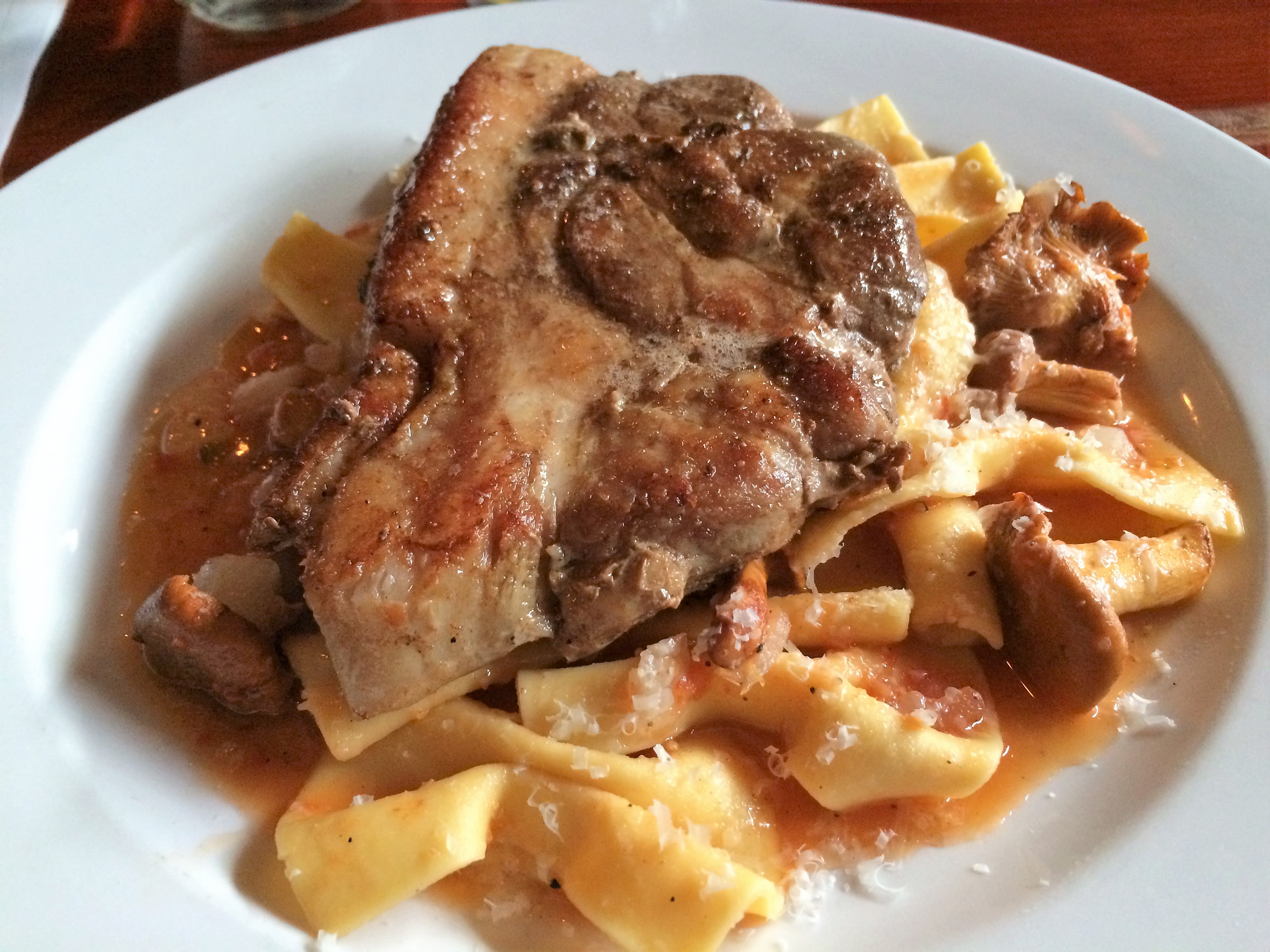 Pork Steak on a bed of mushrooms, tomato and farfalle.